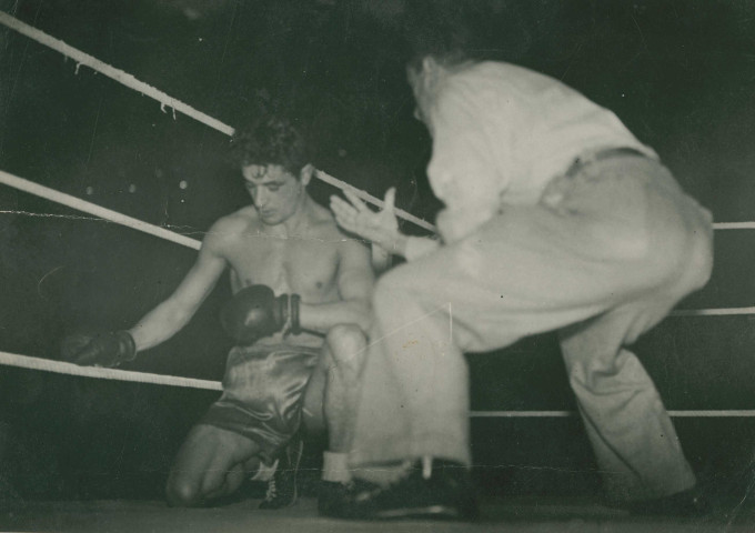 Boxeur au repos et son coach sur un ring : photographie noir et blanc.