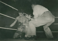 Boxeur au repos et son coach sur un ring : photographie noir et blanc.