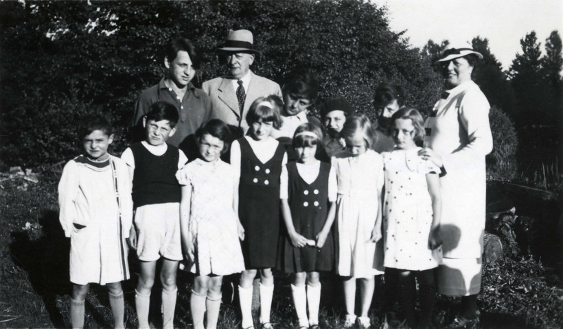 Colonies de vacances dans le nord du Morvan, groupe d'enfants posant avec le maire Charles Auray et son épouse à Vic-sous-Thil : photographie noir et blanc.