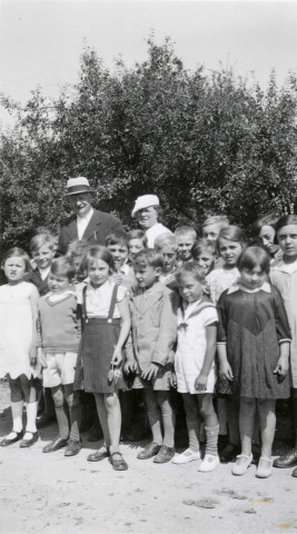 Colonies de vacances dans le nord du Morvan, groupe d'enfants posant avec le maire Charles Auray et son épouse : photographie noir et blanc.