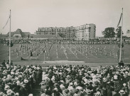 Fête d'éducation physique, vue large sur les mouvements d'ensemble, les spectateurs et les alentours au nord du stade : photographie noir et blanc.