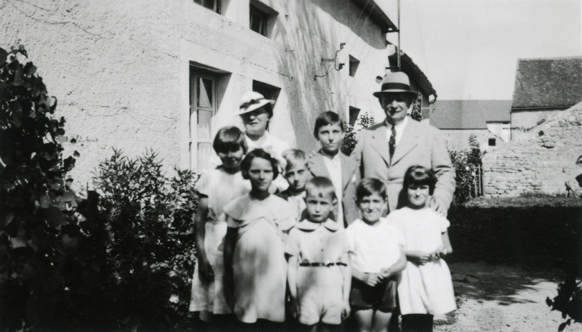 Colonies de vacances dans le nord du Morvan, groupe d'enfants posant avec le maire Charles Auray et son épouse : photographie noir et blanc.