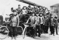 Pompiers à vélo et avec un véhicule motorisé : reproduction de photographie noir et blanc.