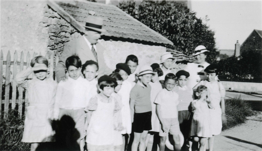 Colonies de vacances dans le nord du Morvan, groupe d'enfants posant avec le maire Charles Auray et son épouse au pont d'Aisy à Collemoine : photographie noir et blanc.