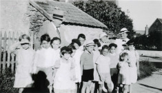 Colonies de vacances dans le nord du Morvan, groupe d'enfants posant avec le maire Charles Auray et son épouse au pont d'Aisy à Collemoine : photographie noir et blanc.