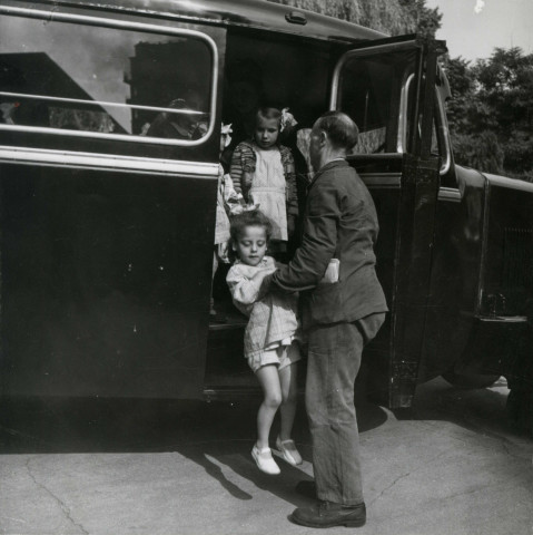 École de Plein-Air, enfants descendant du car scolaire : photographie noir et blanc.
