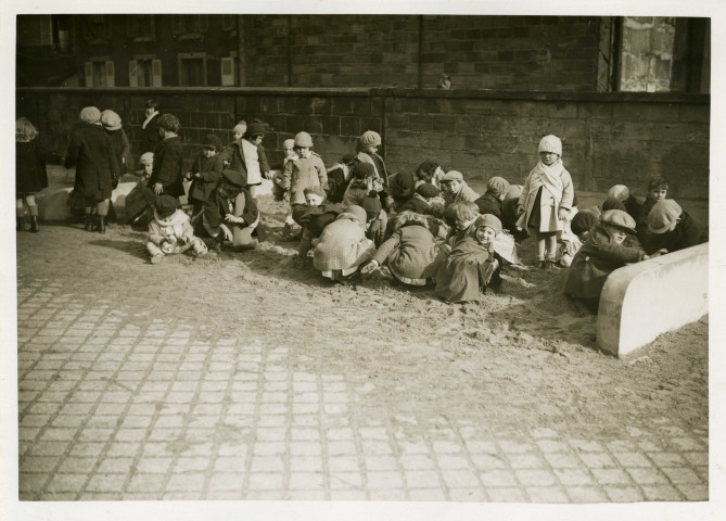 École maternelle de la route des Petits-Ponts, enfants jouant dans un bac à sable : photographie noir et blanc.