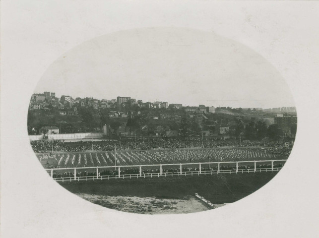 Fête d'éducation physique, vue large sur les mouvements d'ensemble, les spectateurs et les alentours au sud du stade : photographie noir et blanc.