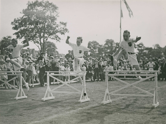 Fête d'éducation physique, démonstration de saut de haies : photographie noir et blanc.