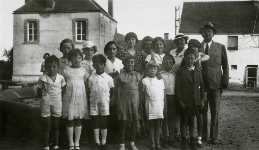 Colonies de vacances dans le nord du Morvan, groupe d'enfants posant avec le maire Charles Auray et son épouse au vieux château de Champmorlin : photographie noir et blanc.