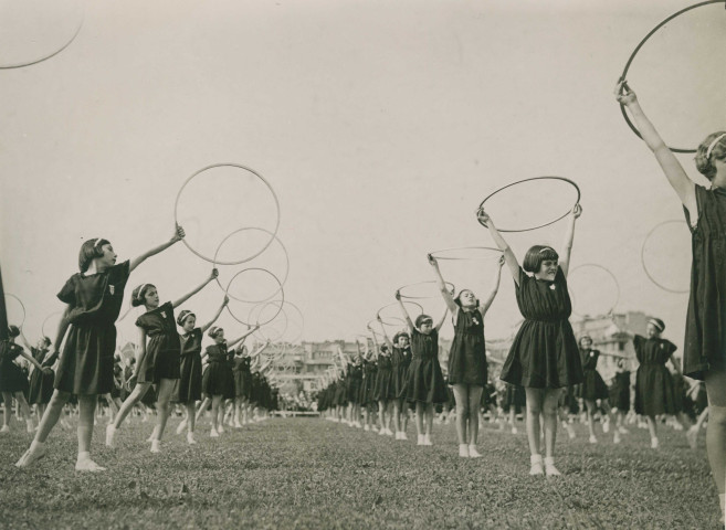 Fête d'éducation physique, mouvements d'ensemble avec des cerceaux : photographie noir et blanc.