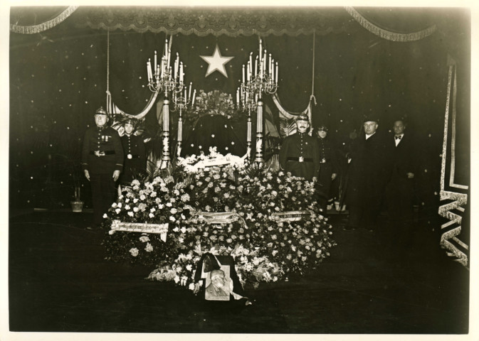 Enterrement du maire Charles Auray, cercueil et corbeilles de fleurs dans l'hôtel de ville : photographie noir et blanc.