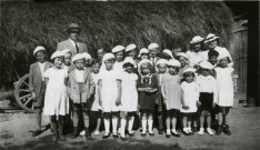 Colonies de vacances dans le nord du Morvan, groupe d'enfants posant avec le maire Charles Auray et son épouse à Corsaint-Montmilien : photographie noir et blanc.