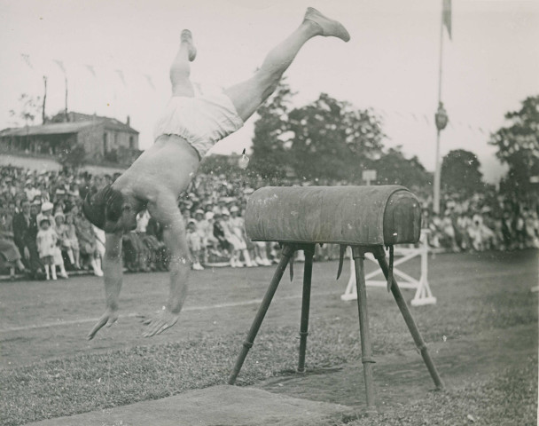 Fête d'éducation physique, démonstration de saut sur cheval d'arçon : photographie noir et blanc.
