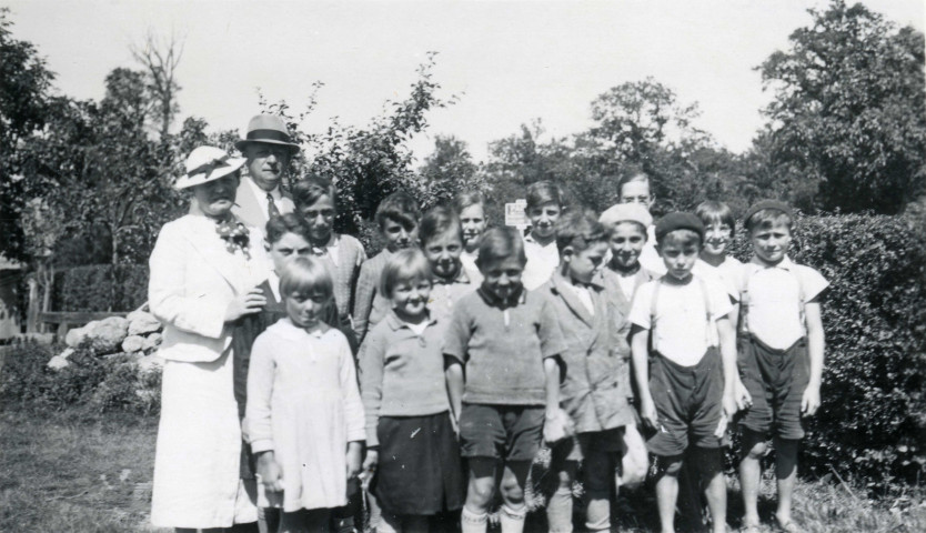 Colonies de vacances dans le nord du Morvan, groupe d'enfants posant avec le maire Charles Auray et son épouse à La Croisée Vernon : photographie noir et blanc.