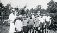 Colonies de vacances dans le nord du Morvan, groupe d'enfants posant avec le maire Charles Auray et son épouse à La Croisée Vernon : photographie noir et blanc.