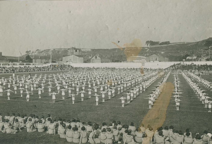 Fête d'éducation physique, vue large sur les mouvements d'ensemble, les spectateurs et les alentours à l'est du stade : photographie noir et blanc.