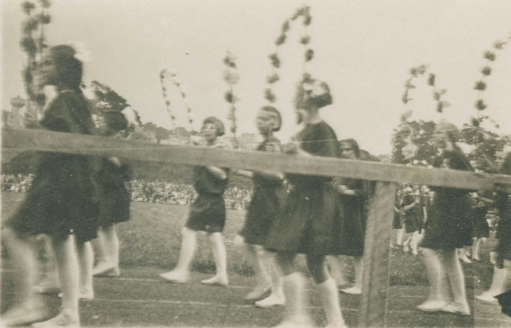 Fête d'éducation physique, mouvements d'ensemble avec des cerceaux fleuris : photographie noir et blanc.