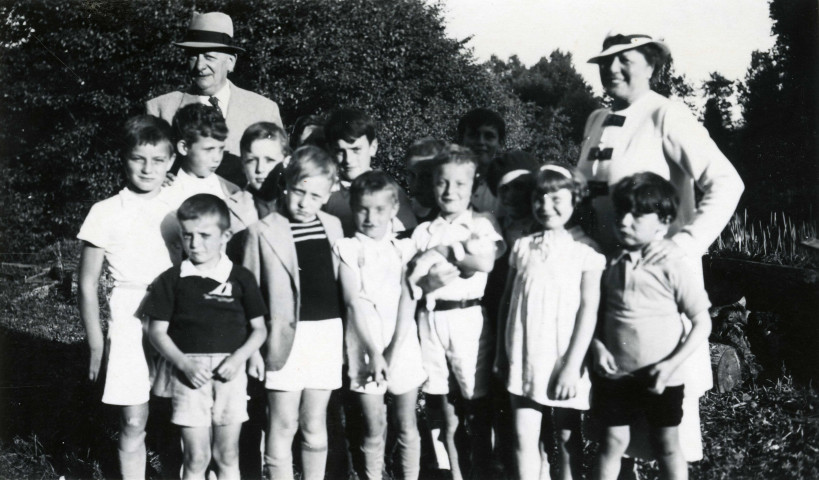 Colonies de vacances dans le nord du Morvan, groupe d'enfants posant avec le maire Charles Auray et son épouse à Vic-sous-Thil : photographie noir et blanc.