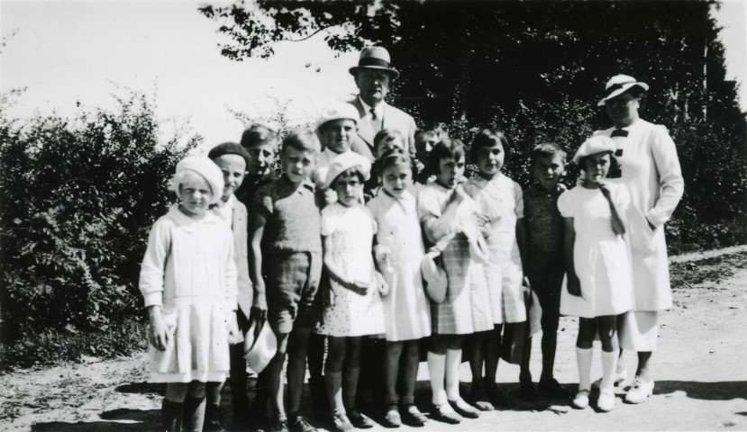Colonies de vacances dans le nord du Morvan, groupe d'enfants posant avec le maire Charles Auray et son épouse aux Chéreaux : photographie noir et blanc.