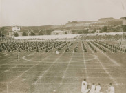 Fête d'éducation physique, vue large sur les mouvements d'ensemble, les spectateurs et les alentours à l'est du stade : photographie noir et blanc.