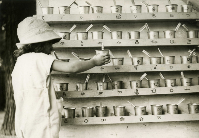 École de Plein-Air, enfant rangeant son gobelet et sa brosse à dents : photographie noir et blanc.