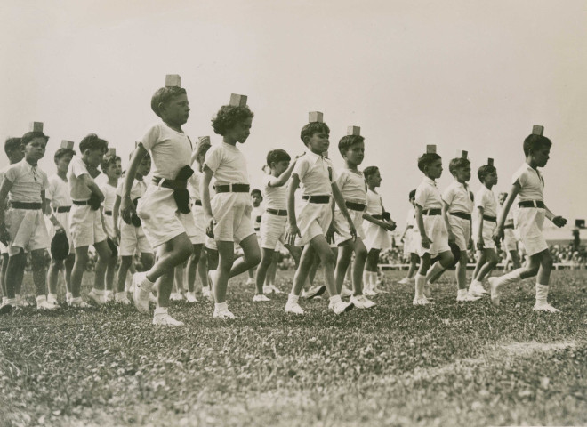Fête d'éducation physique, marche avec un cube sur la tête : photographie noir et blanc.