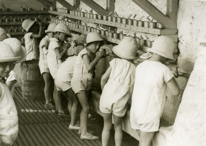 École de Plein-Air, enfants se brossant les dents devant un lavabo : photographie noir et blanc.