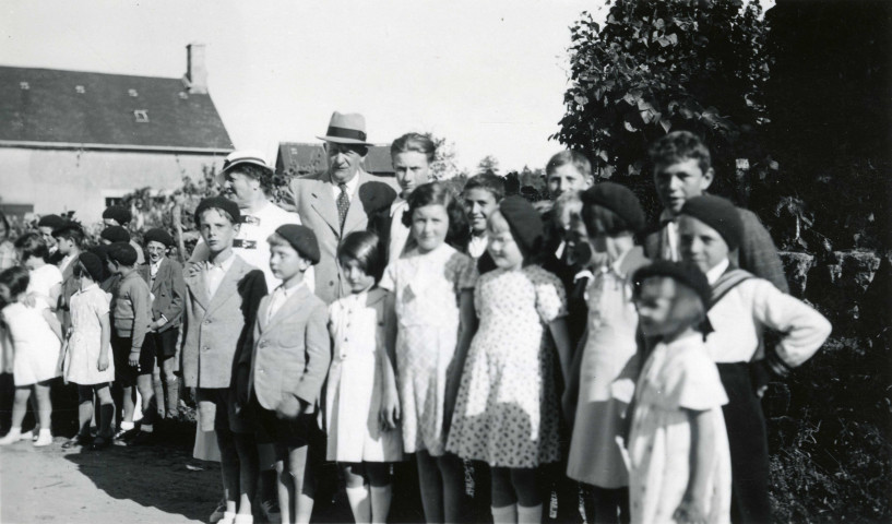 Colonies de vacances dans le nord du Morvan, groupe d'enfants posant avec le maire Charles Auray et son épouse à Montacheu-Grandvault : photographie noir et blanc.