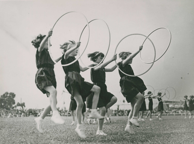 Fête d'éducation physique, mouvements d'ensemble avec des cerceaux : photographie noir et blanc.