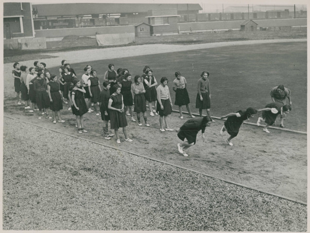 Jeunes filles courant sur le stade Sadi-Carnot : photographie noir et blanc.