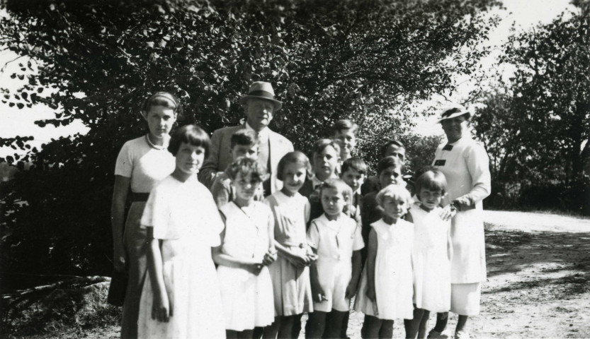 Colonies de vacances dans le nord du Morvan, groupe d'enfants posant avec le maire Charles Auray et son épouse au Jarnoy : photographie noir et blanc.