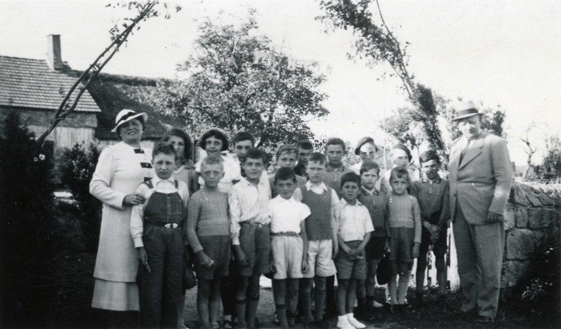Colonies de vacances dans le nord du Morvan, groupe d'enfants posant avec le maire Charles Auray et son épouse à Chauteau Maisonbeaude : photographie noir et blanc.