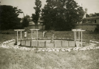 École de Plein-Air, enfants faisant la sieste ou prenant un bain de soleil en cercle autour d'un bac à sable : photographie noir et blanc.