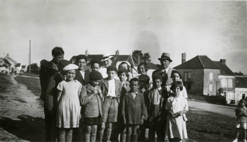 Colonies de vacances dans le nord du Morvan, groupe d'enfants posant avec le maire Charles Auray et son épouse au Foulon (Rouvray) : photographie noir et blanc.