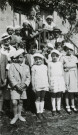 Colonies de vacances dans le nord du Morvan, groupe d'enfants posant avec le maire Charles Auray et son épouse au Pothenée : photographie noir et blanc.