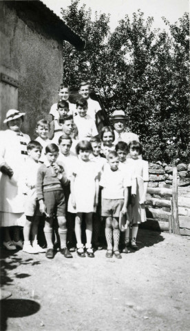 Colonies de vacances dans le nord du Morvan, groupe d'enfants posant avec le maire Charles Auray et son épouse à Champeaubeau : photographie noir et blanc.
