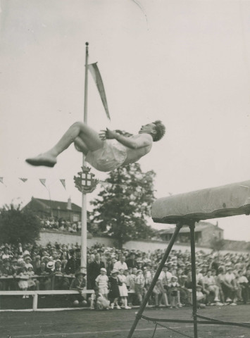 Fête d'éducation physique, démonstration de saut sur cheval d'arçon : photographie noir et blanc.