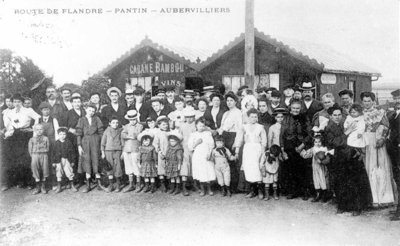 Route de Flandre, groupe d'habitants devant la « Cabane Bambou » : reproduction d'une carte postale.