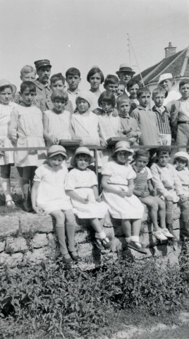 Colonies de vacances dans le nord du Morvan, groupe d'enfants posant avec le maire Charles Auray et son épouse au Foulon (Rouvray) : photographie noir et blanc.