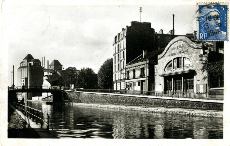 Canal de l'Ourcq avec en premier plan le cinéma Pantin-Palace et en arrière-plan les Grands Moulins : carte postale noir et blanc.