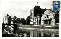 Canal de l'Ourcq avec en premier plan le cinéma Pantin-Palace et en arrière-plan les Grands Moulins : carte postale noir et blanc.