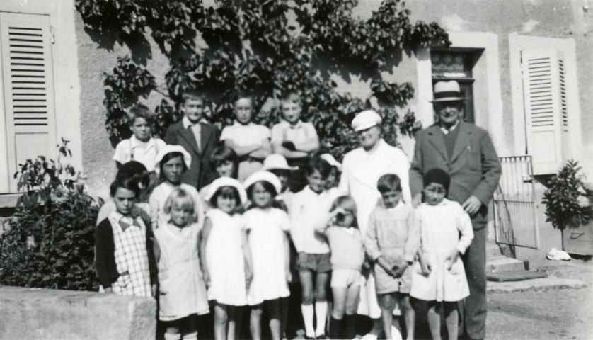 Colonies de vacances dans le nord du Morvan, groupe d'enfants posant avec le maire Charles Auray et son épouse : photographie noir et blanc.