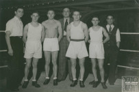 Portrait de groupe de boxeurs en tenue de combat sur un ring à Montargis : photographie noir et blanc.