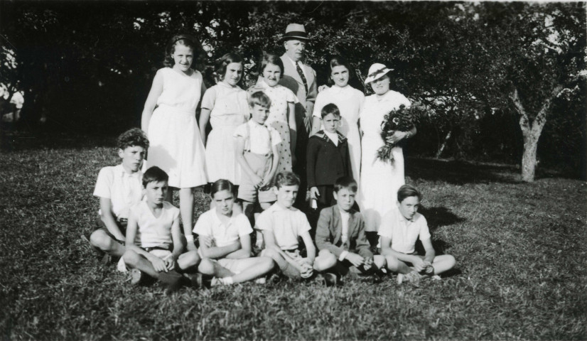 Colonies de vacances dans le nord du Morvan, groupe d'enfants posant avec le maire Charles Auray et son épouse à Courcelles-Frémoy : photographie noir et blanc.