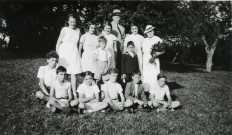 Colonies de vacances dans le nord du Morvan, groupe d'enfants posant avec le maire Charles Auray et son épouse à Courcelles-Frémoy : photographie noir et blanc.