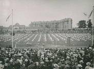 Fête d'éducation physique, vue large sur les mouvements d'ensemble, les spectateurs et les alentours au nord du stade : photographie noir et blanc.