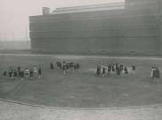 Jeunes filles jouant au ballon sur le stade Sadi-Carnot : photographie noir et blanc.