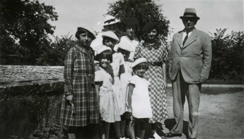 Colonies de vacances dans le nord du Morvan, groupe d'enfants posant avec le maire Charles Auray et son épouse à Thoste : photographie noir et blanc.