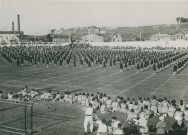 Fête d'éducation physique, vue large sur les mouvements d'ensemble, les spectateurs et les alentours à l'est du stade : photographie noir et blanc.
